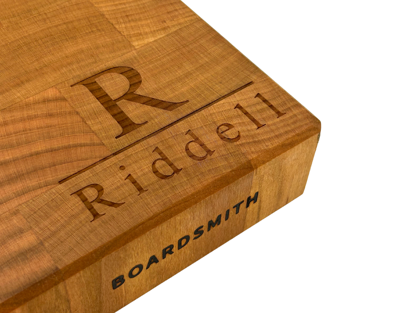 Custom engraved end grain cherry cutting board with Riddell monogram and The Boardsmith branding